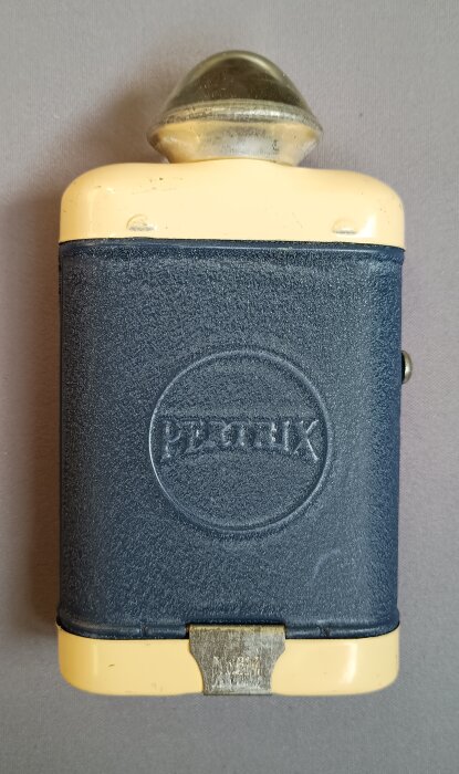 Äldre ficklampa med blått hölje och gult handtag, märkt Negrix, för 4,5 volts batteri.
