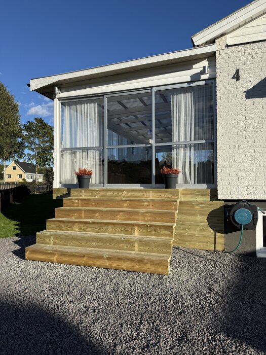 Bred trätrappa under konstruktion vid altanentré, trappans stomme är färdig.