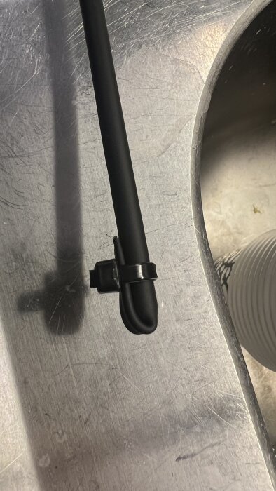 Krympslang med buntband på växtstöd, liggande på metallyta.