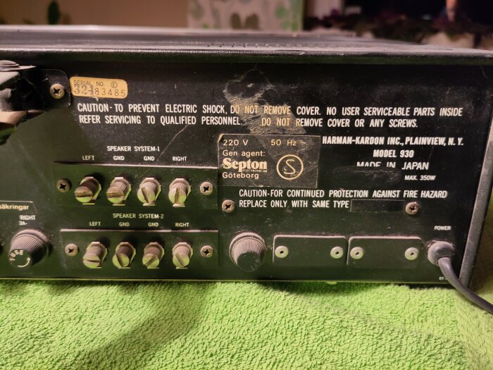 Baksidan av en Harman-Kardon förstärkare, modell 930, med japansk tillverkning, etiketter och varningstexter synliga.