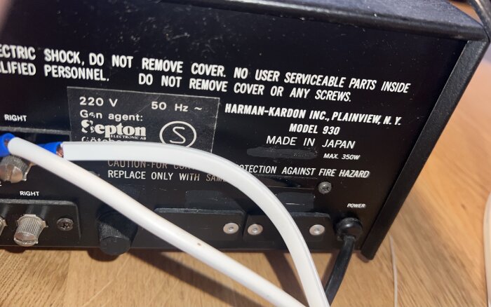 Baksida av en Harman-Kardon modell 930 förstärkare, med text om säkerhetsvarningar och specifikationer. Ingen fyrkantssymbol ses.