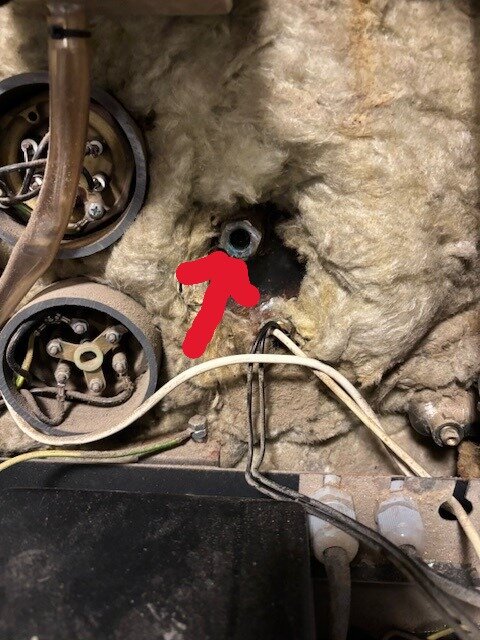 Biomatic 20+ från 2006 med läcka vid fjädrande pigg bakom displayen, isolering och rör synligt, röd pil markerar problemområdet.