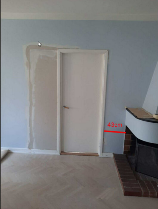 Dörröppning nära hörnspis; 43 cm från spisen till dörrkarmen. Golvet och sockeln är 75 cm från eldstaden.