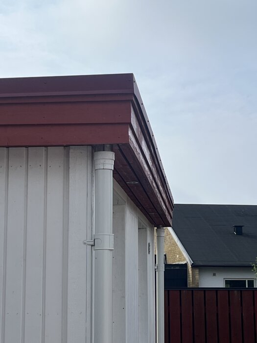 Husvägg med avlägsnade fönsterfoder och monterade fönsterbleck, vit fasad och rödbrunt tak, diskussion om att återmontera foder.