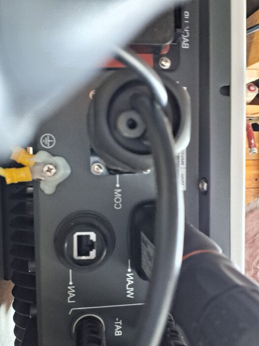 Inkommande anslutning på en enhet med portar märkta COM, LAN, WAN och BAT, troligen kopplad till en extern antenn.