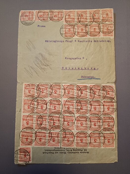 Vintage kuvert med flera röda frimärken stämplade med datum och adresserat till ett företag i Helsingborg, Sverige.
