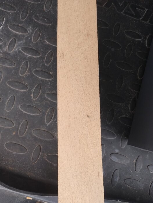 Träbit på svart yta, fråga om träslag.