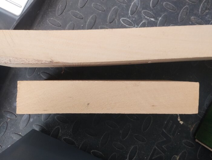 Två träbitar på en yta, diskussion om material, eventuell bok.