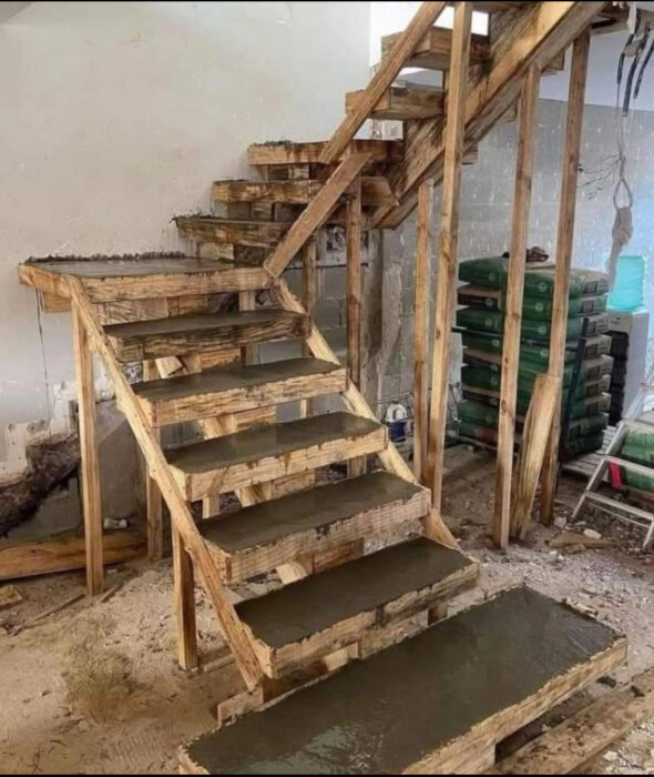 Trappa under konstruktion med träformar runt betongsteg, ifrågasatt stabilitet efter formborttagning.