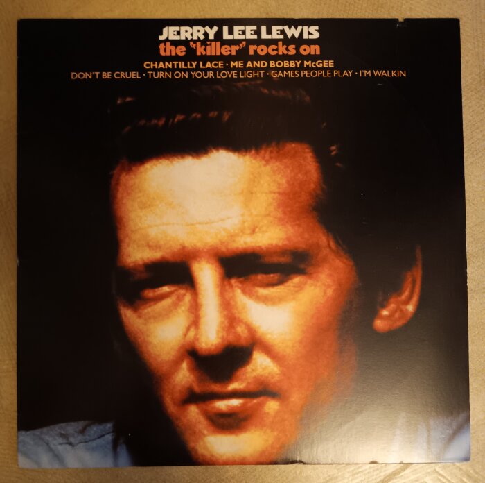 Omslag av albumet "The Killer Rocks On" med text och ansiktsbild.