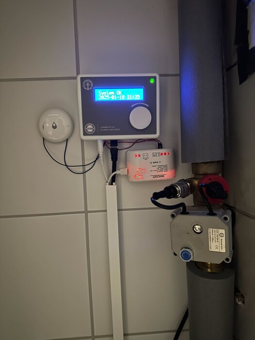 Vatette-kontrollpanel monterad på väggen, ansluten till vattenläckagesensor och relä för att styra och övervaka vattenflöde.