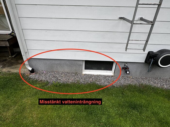 Stuprör vid husgrund med misstänkt vatteninträngning; marken lutar mot huset.