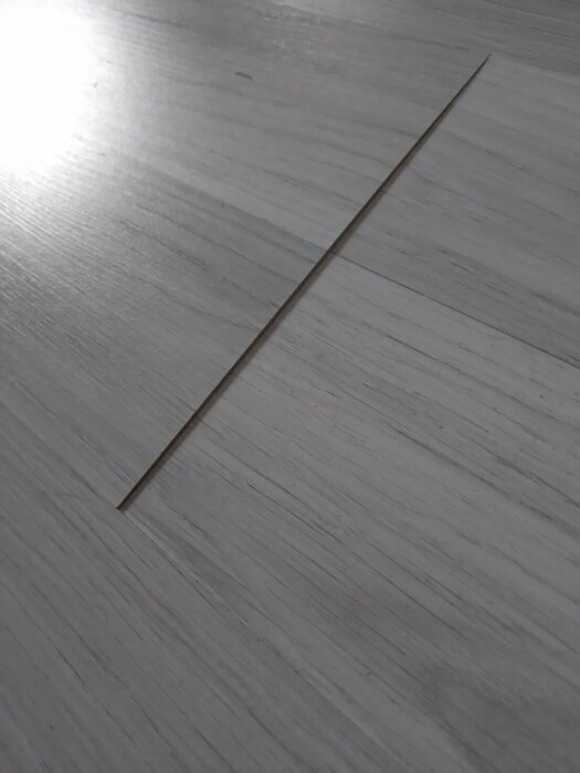 Clickgolvs-skarv som rest sig över resten av golvet och bildar en kant.