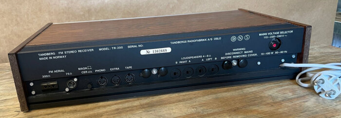 Baksidan av en Tandberg FM stereo receiver TR-200 med anslutningar för antenn, högtalare och andra enheter, samt en strömkabel.