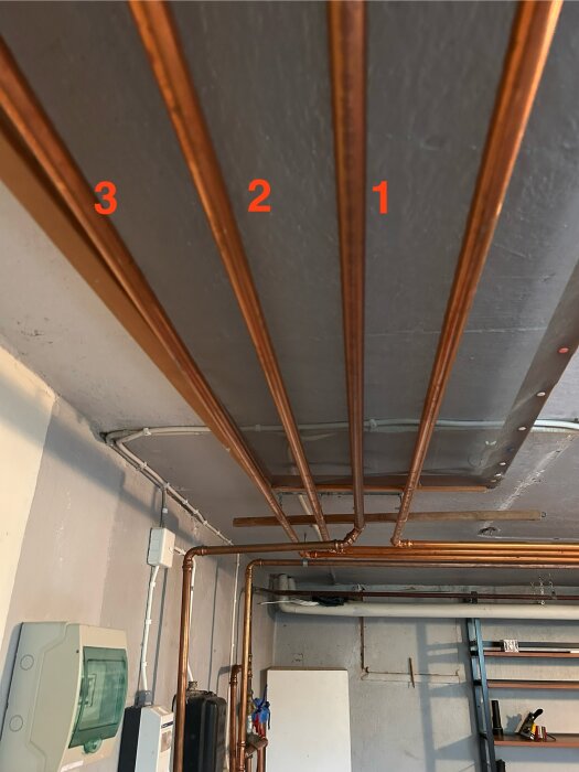 Kopparrör i taket med numrering 1, 2, 3. Rör 1 leder längre bort från pumpen.