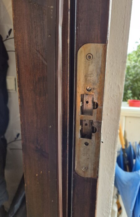 Dörrkarm i trä med ett äldre lås från ASSA synligt, fotograferat på nära håll i ett radhus från 1979.