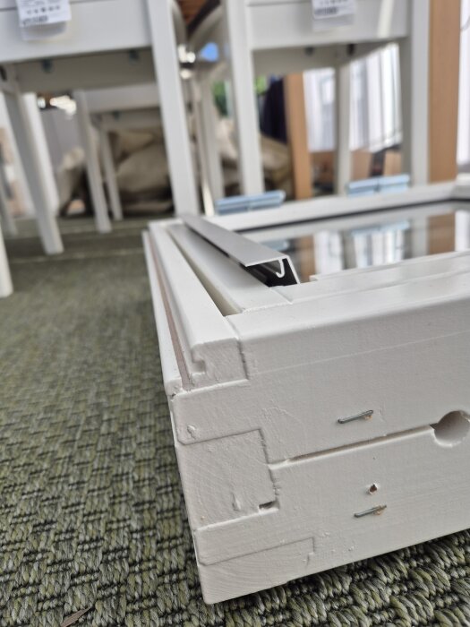 Solid Elements-fönster med komplicerad nedre karmdesign på en grön matta, visar fästens position och skårans bredd.