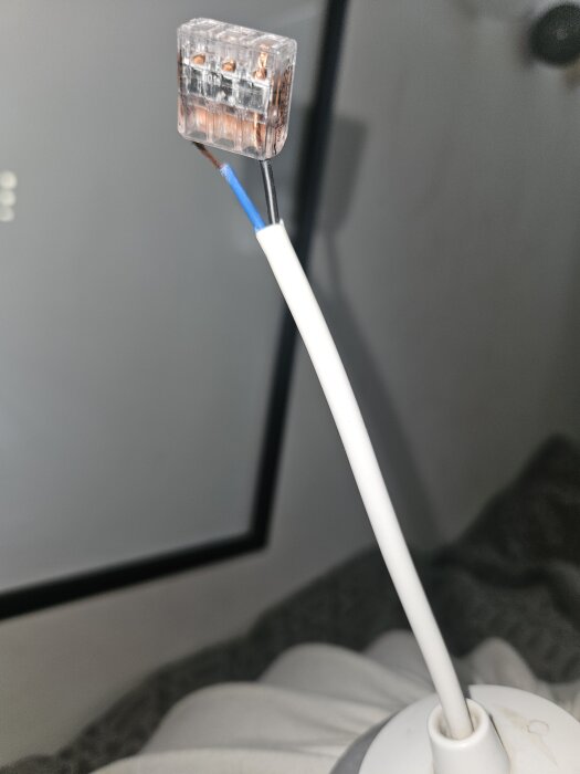 Ledningsstump med blå och svart kabel anslutna till en kopplingsklämma.