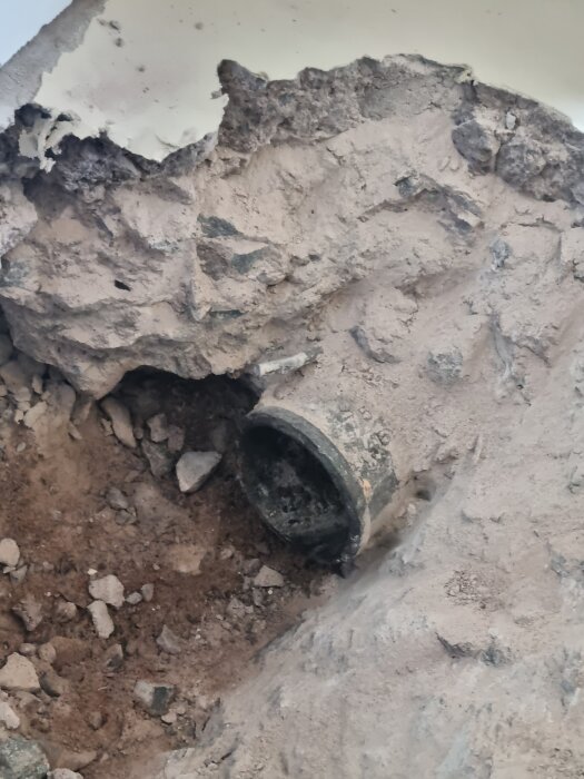 Rör avgröpt i stenvägg för montering av ny brunn; det invändiga röret mäter 95mm, och brunnen 75cm.