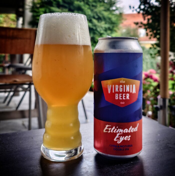 Ett glas med skummande öl och en burk etiketterad "Virginia Beer Co., Estimated Eyes, Citra & Motueka Double IPA".