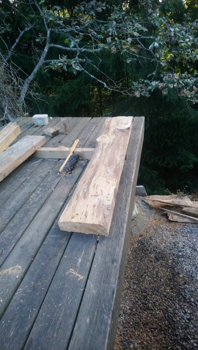 Grovhuggen ekbit och pensel på träbord i skogsmiljö.