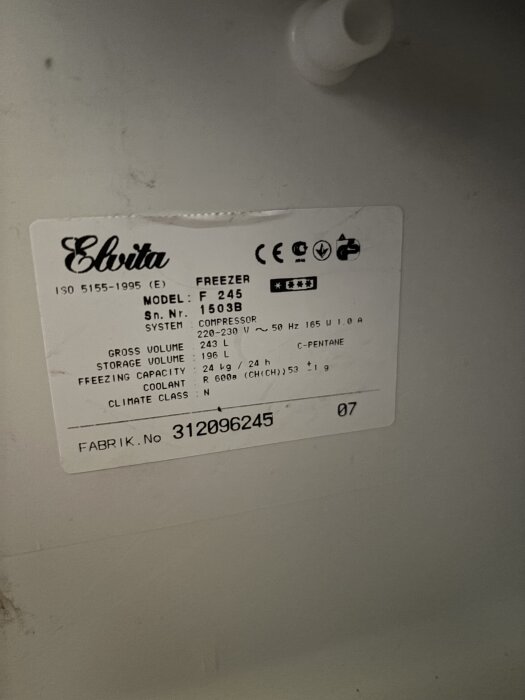 Etikett på Elvita frysskåp F 245 med information om modell, serienummer, volym och köldmedium.