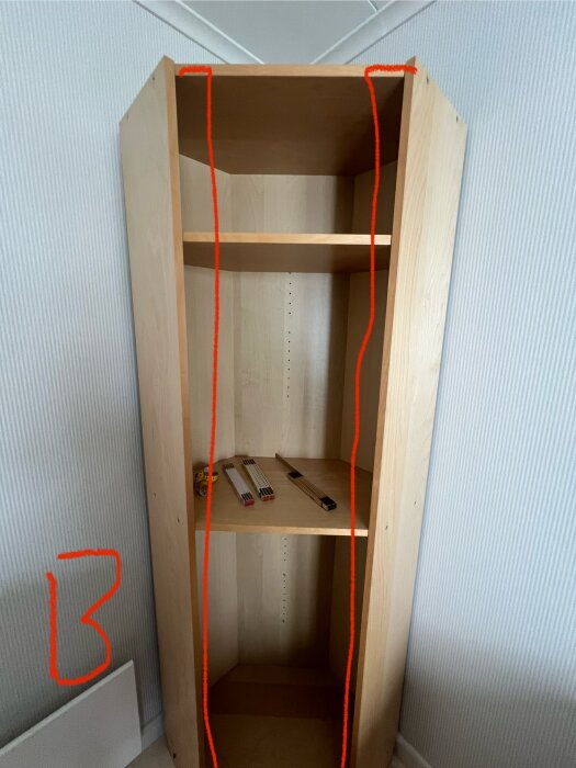 Gammal billy hörnbokhylla med två hyllplan, omgiven av röda markeringar för en planerad dörrinstallation.