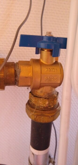 Ventil med blå handtag märkt "PN25" och "A2409", monterad på mässingsrör, möjligt vattentrycksproblem efter byte.