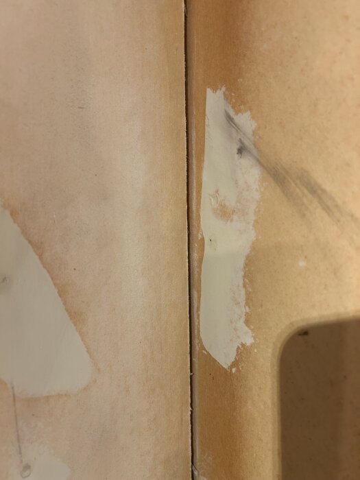 Innerhörn av suterrängvåning med lättklinkerblock, visar delvis spacklade gipsskivor med ljusa och mörka fläckar, nära modifieringar.