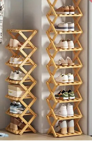 Trähylla för skor i zickzackmodell med flera hyllplan fyllda med olika skor.