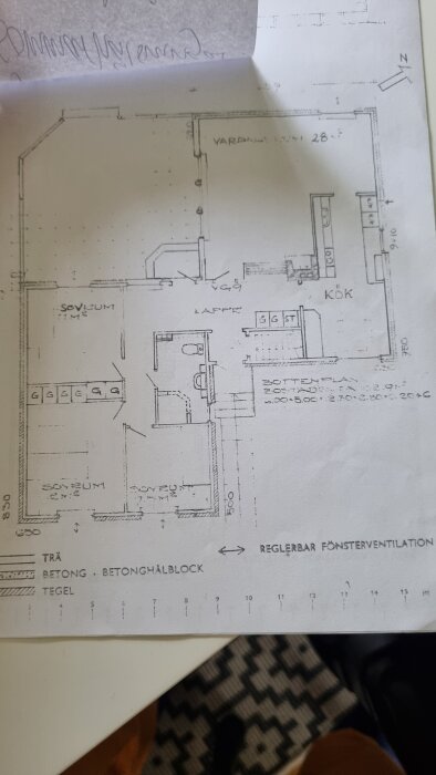 Planlösning över husets bottenvåning med rum såsom vardagsrum, kök och sovrum markerade.