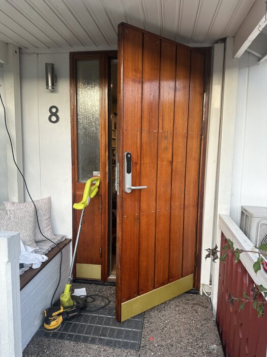 Trädörr med installerat Yale Doorman Classic lås, omgiven av slipverktyg och inoljade ytor.