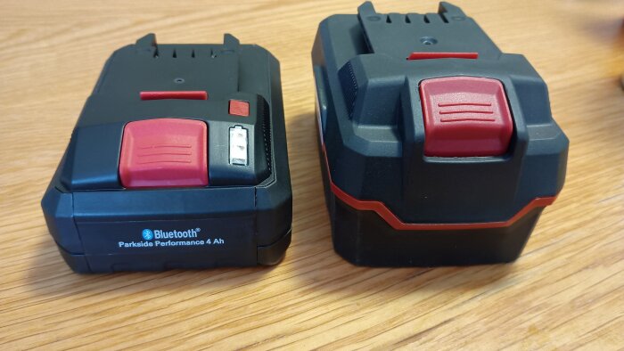 Två uppladdningsbara batterier på ett träbord, ett med Bluetooth-funktion, märkta "Parkside Performance 4 Ah".
