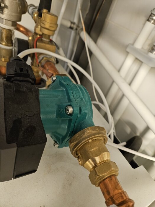 Vattenpump med kopparrör i ett teknikrum; används för att diskutera tryckproblem.