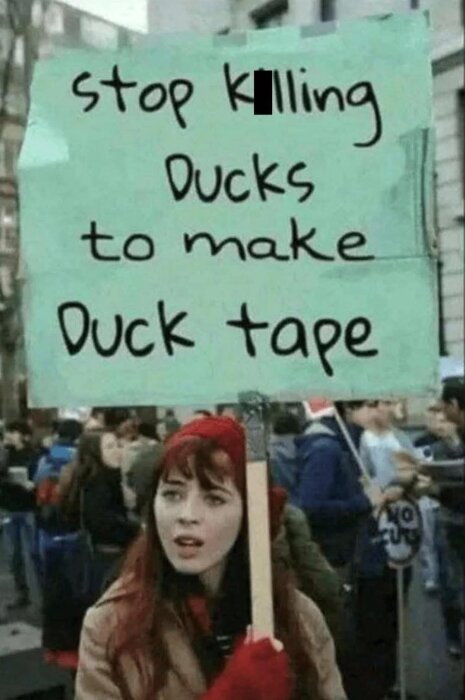Protest med kvinna som håller i en skylt med texten "Stop killing ducks to make duck tape.