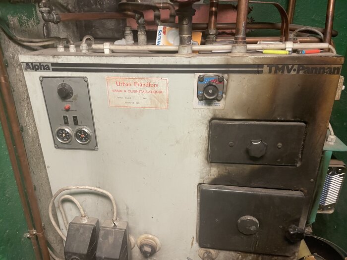 Äldre Alpha TMV kombipanna från 1986 med mätskala och rör ovanpå, använd i fråga om påfyllning av vatten och tryckinställning.