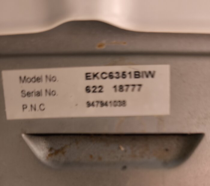 Skylt med modellnummer EKC6351BIW, serienummer 622 18777 och P.N.C 947941038 på en hushållsapparat.