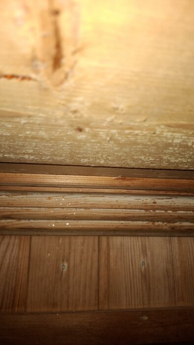 Taket och väggen i en bastu med vitaktig missfärgning på träytan.