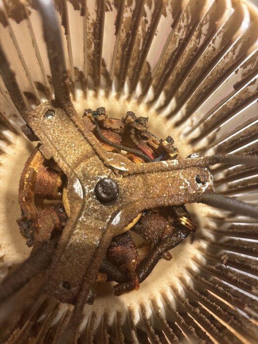 Smutsig köksfläktmotor med ingrodda avlagringar på fläktblad och lindningar, söker rengöringstips utan att ta isär komponenterna.