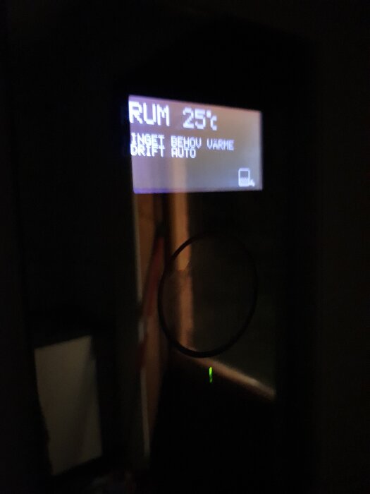 Display på en Thermia värmepump, visar "RUM 25°C", "INGET BEHOV VÄRME", "DRIFT AUTO".