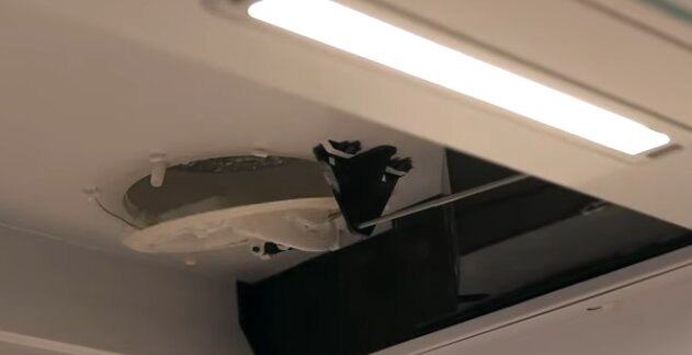 Rengöring av spiskåpa invändigt, visar spjäll och mekanism med metalstång.