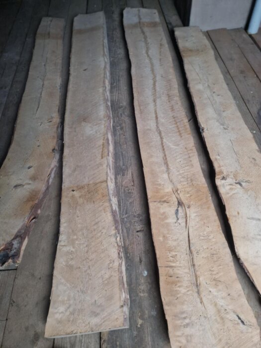 Brädor av gammal björk på golv inför snickeriprojekt, varierande storlek, ska användas till att bygga ett soffbord.