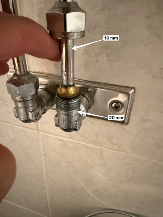 VVS-anslutning med 10 mm rör och 20 mm kulventil, kopplad till tvättställ. Person pekar på området.