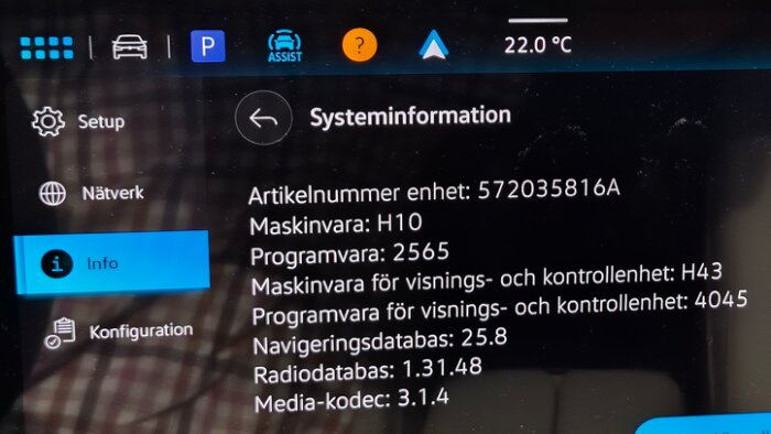 Bild av en bils infotainmentskärm som visar systeminformation som artikelnummer, maskinvara och programvaruversioner.