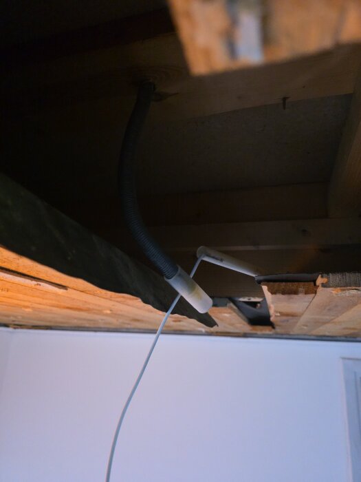 Öppet tak med synligt rör och kablar, viss fukt- och skadekontroll pågår efter läcka.