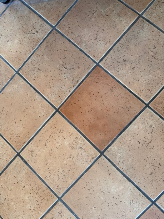 Beige och bruna fyrkantiga kakelplattor med sprickor, används i kök eller hall, cirka 250x250 mm, cirka 25 år gamla.