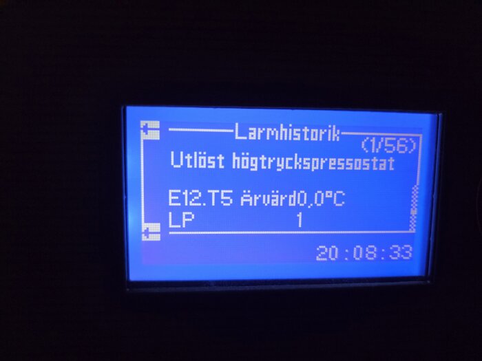 LCD-display som visar larmhistorik för värmepump med meddelandet "Utlöst högtryckspressostat", och värdet E12.T5 Ärvärd 0,0°C.