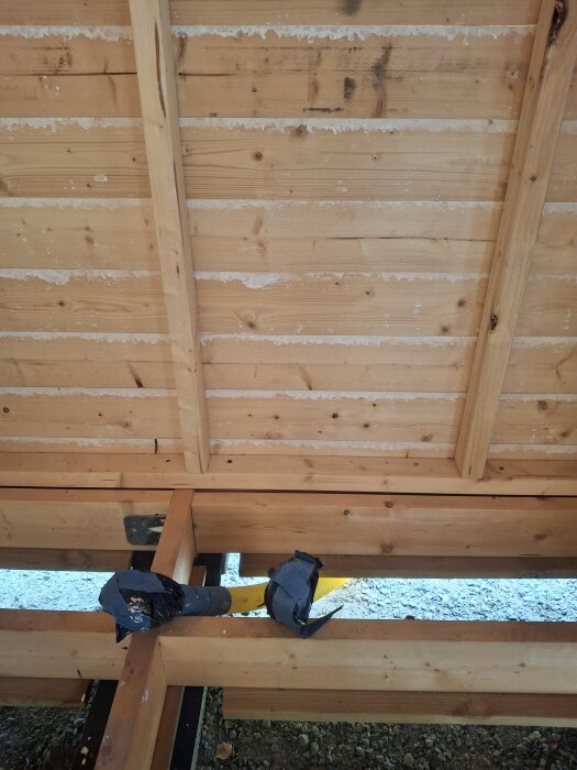 Träram för friggebod under konstruktion med gul slang genom reglar, diskussion om elinstallation.