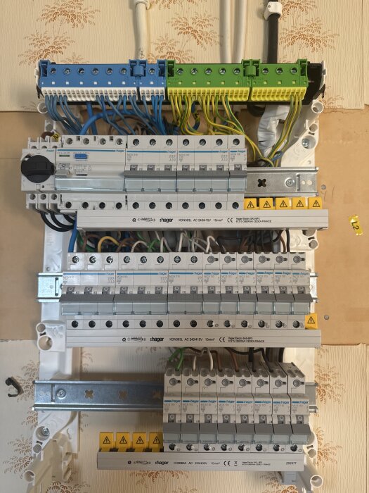 Bild av en elcentral med flera grupper av säkringar och kablar, nyligen bytt till TN-S system, mot en mönstrad väggbakgrund.
