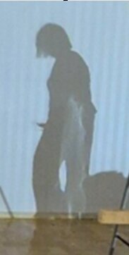 Skugga av en person på en vägg, utan tydliga detaljer.